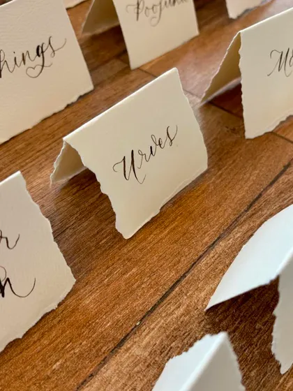 Freehand modern calligraphy on deckled edge place cards is the perfect accompaniment to a sit-down dinner. The torn edges of the handmade paper add a rustic and organic feel.
