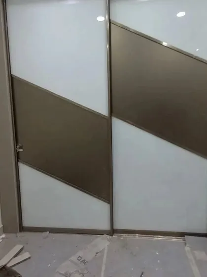 Another Aristo sliding wardrobe design, this one featuring a diagonal two-tone pattern in bronze and white. This shows the level of customization available for our wardrobe solutions.