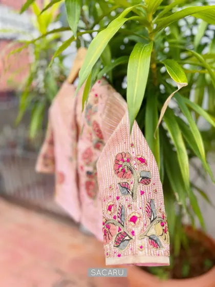 An artistic shot of our Kalamkari patchwork blouse, highlighting the beautiful hand-embroidered floral motif on the sleeve.