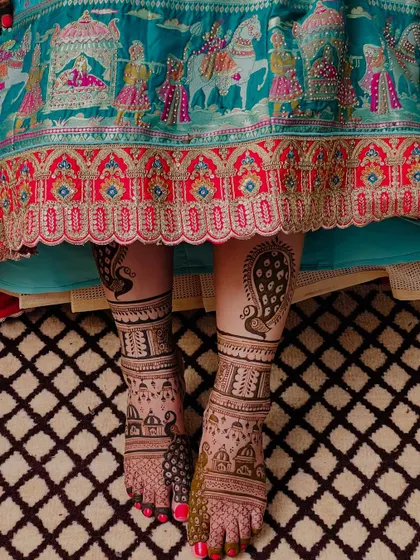 Another view of the peacock lover's foot mehendi, showing how it pairs with a colorful bridal lehenga.