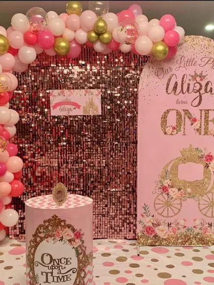 A pink sequin wall adds a touch of royalty to this princess-themed first birthday party for Aliza.