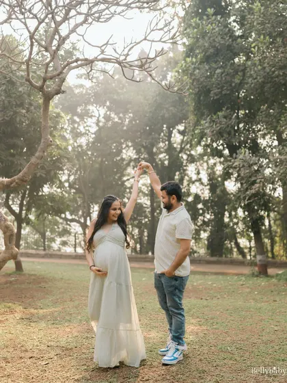 Twirling into parenthood, hand in hand. An outdoor session in a sunlit park is perfect for capturing these lighthearted, dreamy moments.