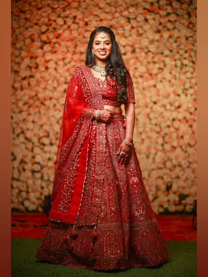 Red magic. This bride is a vision in her traditional red reception lehenga. The makeup is classic and bold, with defined eyes and a radiant complexion.