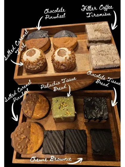 Pinwheels, filter coffee tiramisu, tissue bread and brownies share our wooden display trays, with the flavours labelled.