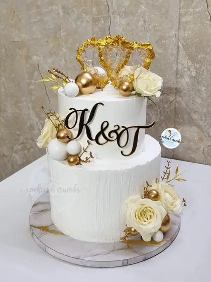 A classic two-tiered wedding cake that is pure elegance. I designed this with a textured buttercream finish, edible crystal hearts, and initial toppers for a personalized touch.