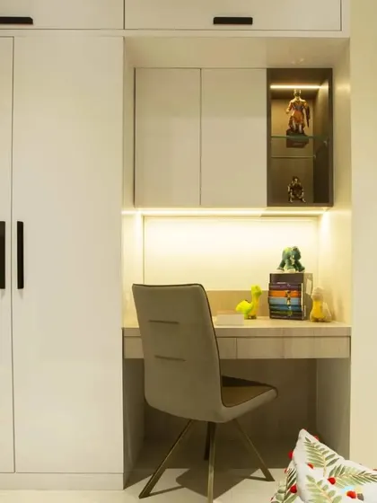 A perfect example of a space-saving design for a kid's room. We integrated a compact study table and a display niche directly into the wardrobe unit, complete with task lighting.