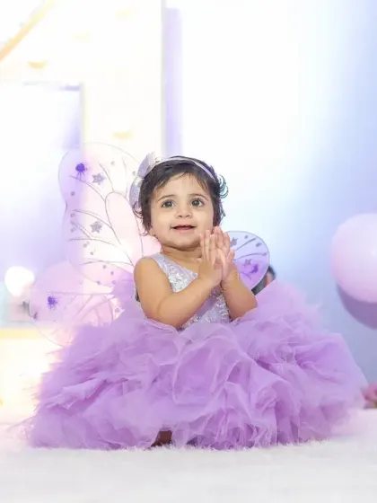 A round of applause for the birthday girl. This happy, clapping shot perfectly captures the joy and excitement of a first birthday celebration.