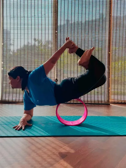 A student practicing a backbend with a yoga wheel. This pose, inspired by another yogi, is a great way to explore new shapes and challenge your flexibility.