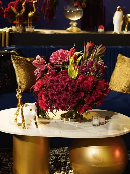 A close-up of the Sangeet lounge, showing the mix of textures from velvet and sequins, and the golden deer prop on the coffee table.