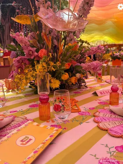 A colorful and eclectic table setting from the Adani Mehendi. The mix of patterns, florals, and custom stationery reflects a joyful and artistic theme, perfectly suited for a vibrant daytime event.
