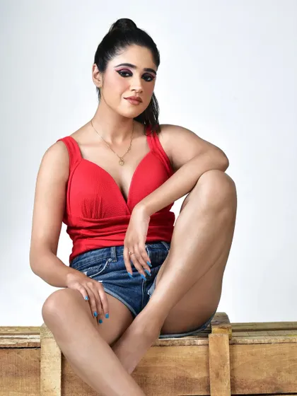 A modern and casual studio look for a commercial photoshoot. The makeup features a dramatic graphic eyeliner with a pop of red, paired with a clean base and nude lips to balance the bold eye.