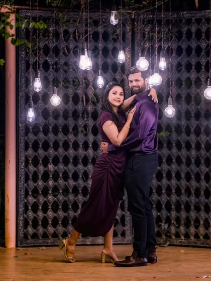 The combination of hanging Edison bulbs and the rustic gate creates an industrial-chic vibe, offering a unique and moody background for your night shoot.