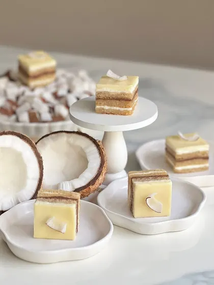 The coconut opera gateau, beautifully plated. The layers are perfectly even, and the fresh coconut on top adds a lovely texture. It's a taste of the tropics.