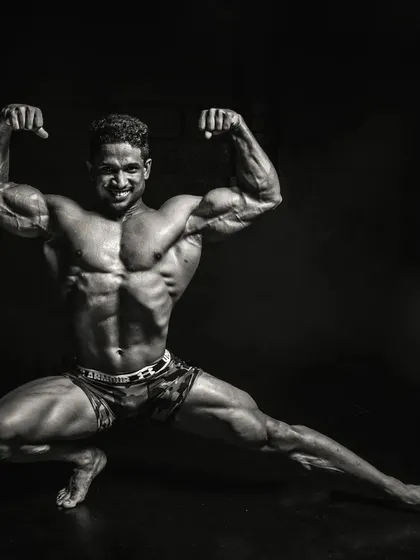 A black and white artistic shot of a classic bodybuilding pose. This highlights the muscle definition, symmetry, and conditioning that I strive for with my clients who are serious about physique development.