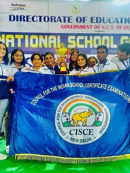 Another shot of our victorious CISCE swim team at the National School Games in Delhi, holding the championship banner and trophy.