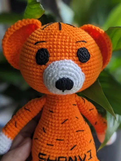A close-up portrait of the custom-named tiger, highlighting its sweet, hand-stitched face.