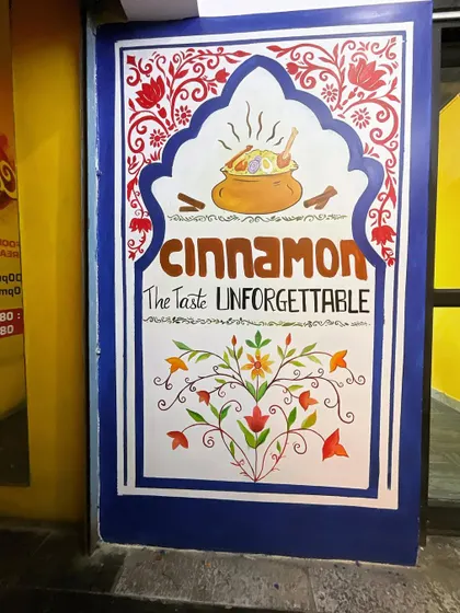 The finished entrance mural for Cinnamon restaurant. The combination of royal blue, red, and intricate patterns creates an inviting and memorable first impression for customers.