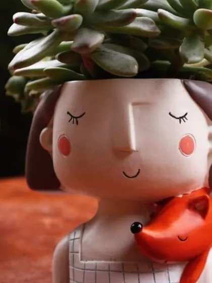 Add a touch of whimsy with our character planters. This one features a girl with a friendly fox, perfect for small succulents.