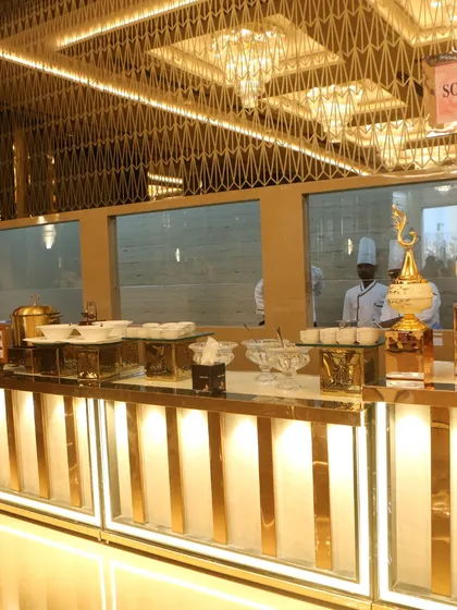 A soup station set against a backdrop of stunning golden latticework and grand chandeliers. This setup highlights our commitment to making every part of the meal, even the soup, feel special.