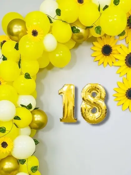 A cheerful sunflower-themed decoration for an 18th birthday. The bright yellow balloons and paper sunflowers create a happy and sunny vibe.