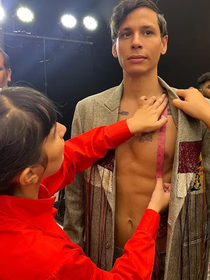 The precision of backstage. Here, I'm taking measurements to ensure the perfect fit for a model's runway look at the Huemn show.