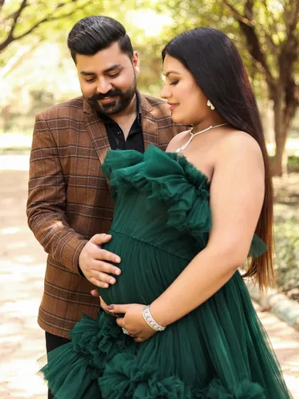 A close up shot focusing on the connection. The father to be gently holds the baby bump, both parents looking down with love and anticipation.