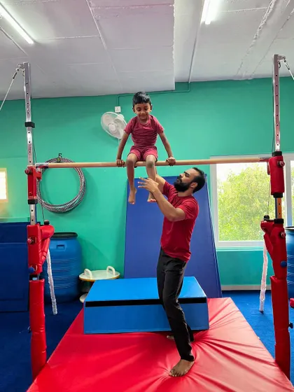 This young gymnast is all smiles as he sits proudly on the high bar. Moments like these, where a child feels strong and accomplished, are what our program is all about.