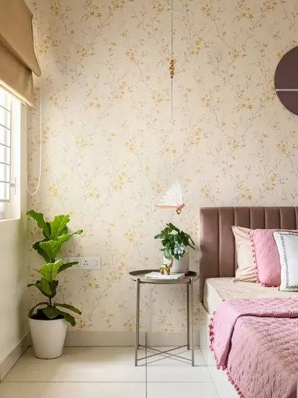This view shows the other side of the pink and white bedroom, with a fiddle leaf fig plant adding a touch of green. The simple side table is both functional and stylish.
