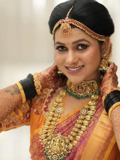 A close-up of a happy bride, her smile as bright as her jewellery. The temple choker and Kasu Mala set is a classic choice that never goes out of style.