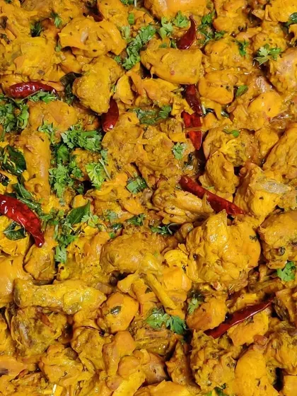 A large batch of our spicy chicken starter, garnished with fresh coriander and red chillies. We can prepare large quantities without compromising on the home-style taste.