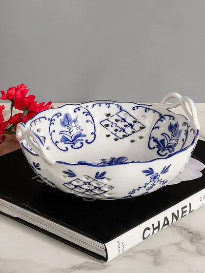 This charming blue pottery bowl with handles is both practical and decorative. The intricate patterns are a testament to its handcrafted origins, making it a lovely piece for serving or display.