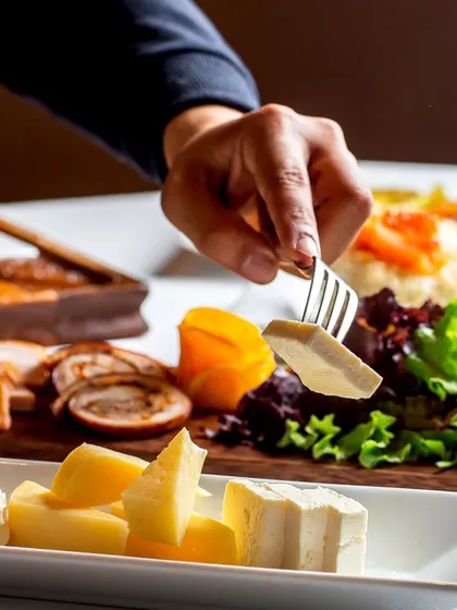 A gourmet cheese and charcuterie platter being served. This demonstrates our expertise in creating sophisticated offerings for upscale events and cocktail parties.