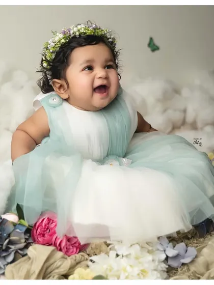 Celebrating six months of pure magic. This little one's happy expression is captured in a dreamy setup with soft clouds and a floral crown. My six-month milestone sessions are designed to showcase your baby's budding personality and those adorable gummy grins.