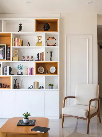 Another view of the living area, showing the custom bookshelf next to the balcony. The design allows for plenty of natural light, making the space feel bright and connected to the outdoors.