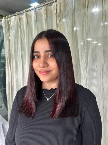 A happy client showing off her new sleek, burgundy look. The color is modern and chic, perfectly complementing her style.