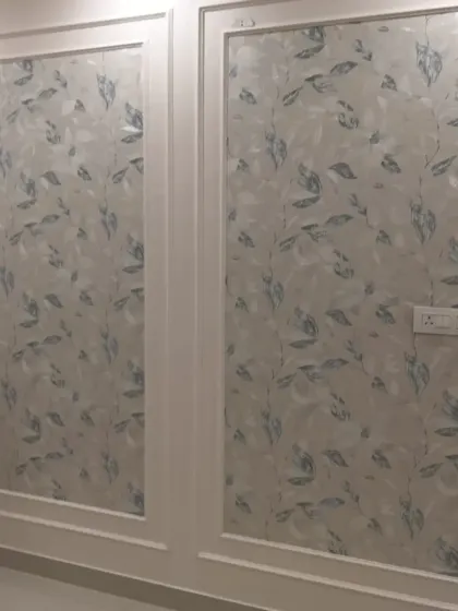 A leaf-patterned wallpaper installed within two large wall panels.