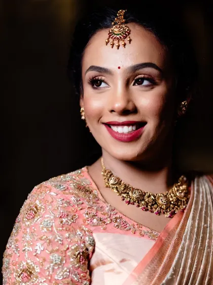 A close-up of our bride in her peach Kanjeevaram, showing her joyful expression and the beautiful detailing of her blouse and jewelry.