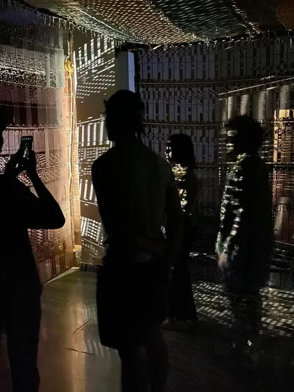 The students' silhouettes against the projected light patterns of the installation.