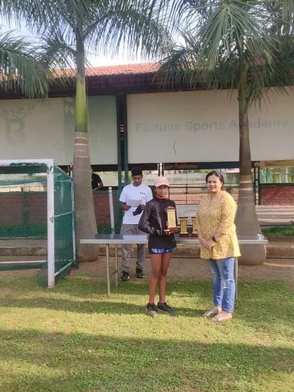 Aditi being presented with her U-12 Runner-Up trophy at our home tournament. Her success is a result of dedicated training and a strong competitive drive.
