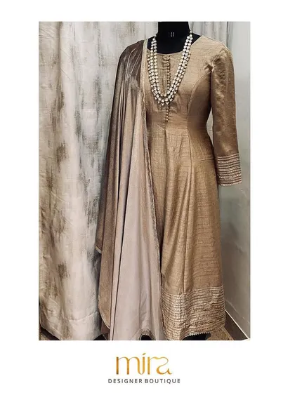 An elegant flared raw silk kurta set in a subtle earthy tone. Paired with a velvet dupatta featuring gotta patti work, this outfit is a sophisticated choice for an intimate pre-wedding event or puja.