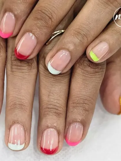 A fun and colorful twist on the French manicure. Each nail has a different colored tip, creating a playful and modern rainbow effect.