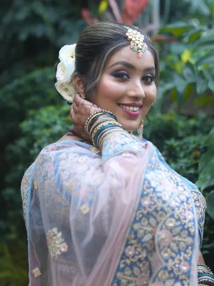 A beautiful outdoor shot from a student's portfolio. The natural light highlights the flawless makeup application.