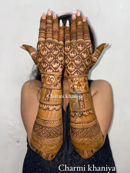 A classic bridal mehendi with full coverage. This design features a dense checkerboard pattern on the hands and the couple's initials, perfect for a traditional wedding look.