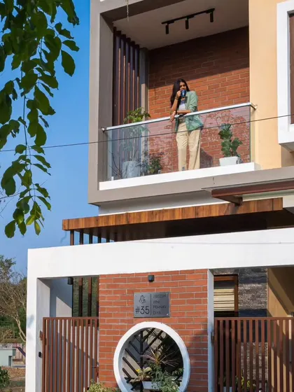 A view from the street of the Sarjapur residence, focusing on the ground floor and the unique circular planter in the compound wall.