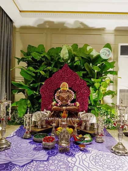 A customized backdrop for a Varamahalakshmi pooja for one of my oldest clients. The goddess is framed by a halo of carnations, with a lush background of banana leaves and silver elephant props.