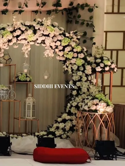 A detailed shot of the floral circle decor, showing the charming accents like a miniature bicycle and birdcage lantern nestled within the arrangement.