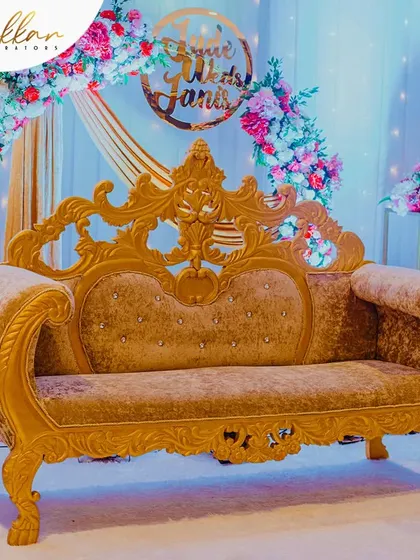 A close-up of the royal gold-finished sofa, a key element in many of my grand reception stage designs. It adds a touch of opulence and provides a perfect seat for the happy couple.