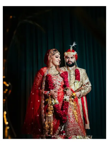 A beautifully lit portrait of the couple against a dark, elegant backdrop. The focus is on their regal outfits and their loving gaze.