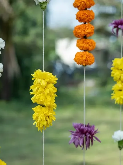 Simple yet beautiful hanging strings of colorful flowers, used as a backdrop to add texture and color to the outdoor event.