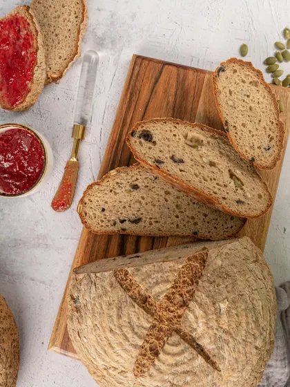 Sliced sourdough bread with jam. This simple, clean shot focuses on the texture of the bread, showcasing its quality for a bakery or cafe.